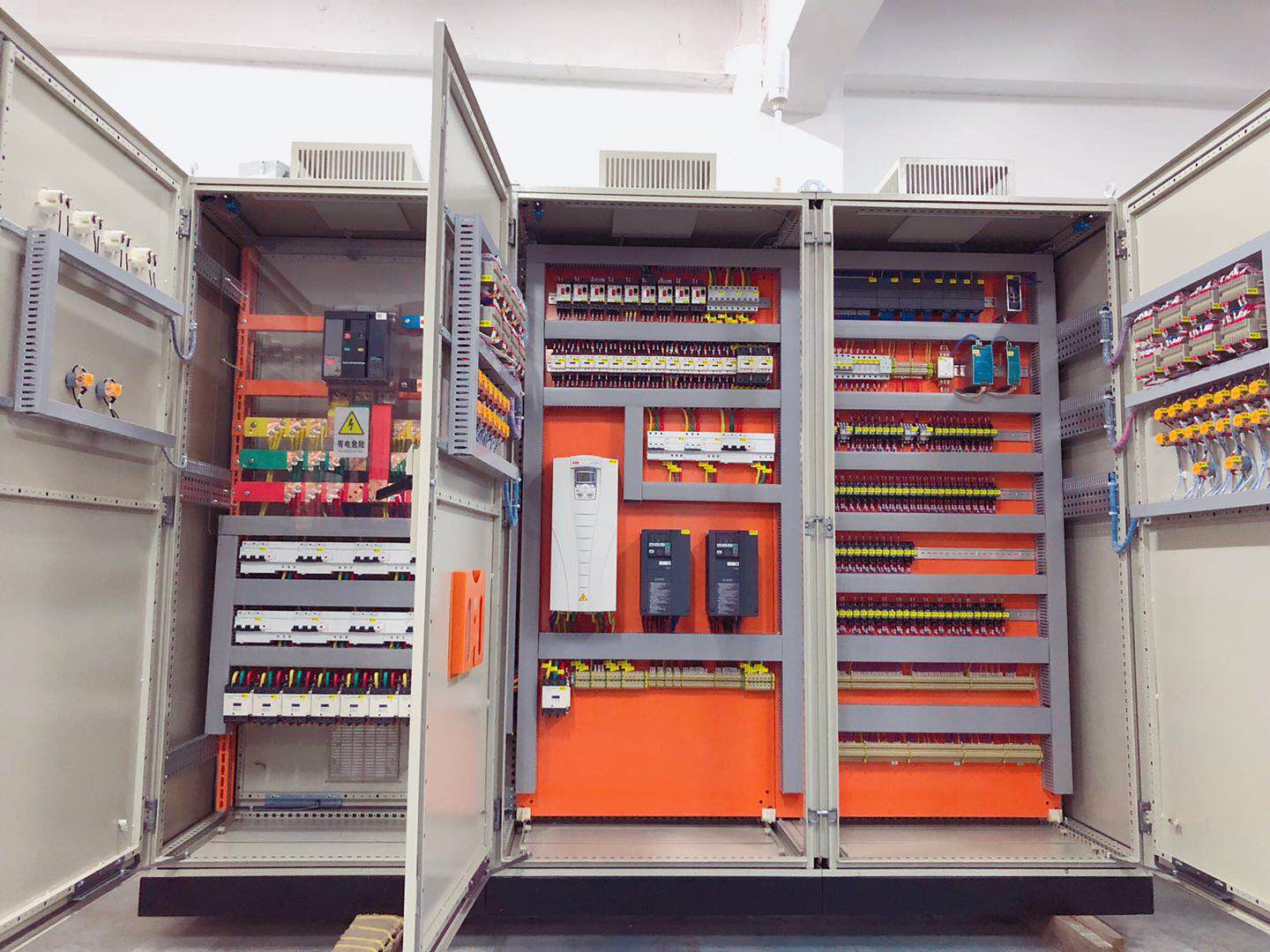 Open electrical control cabinets showing breakers and wiring