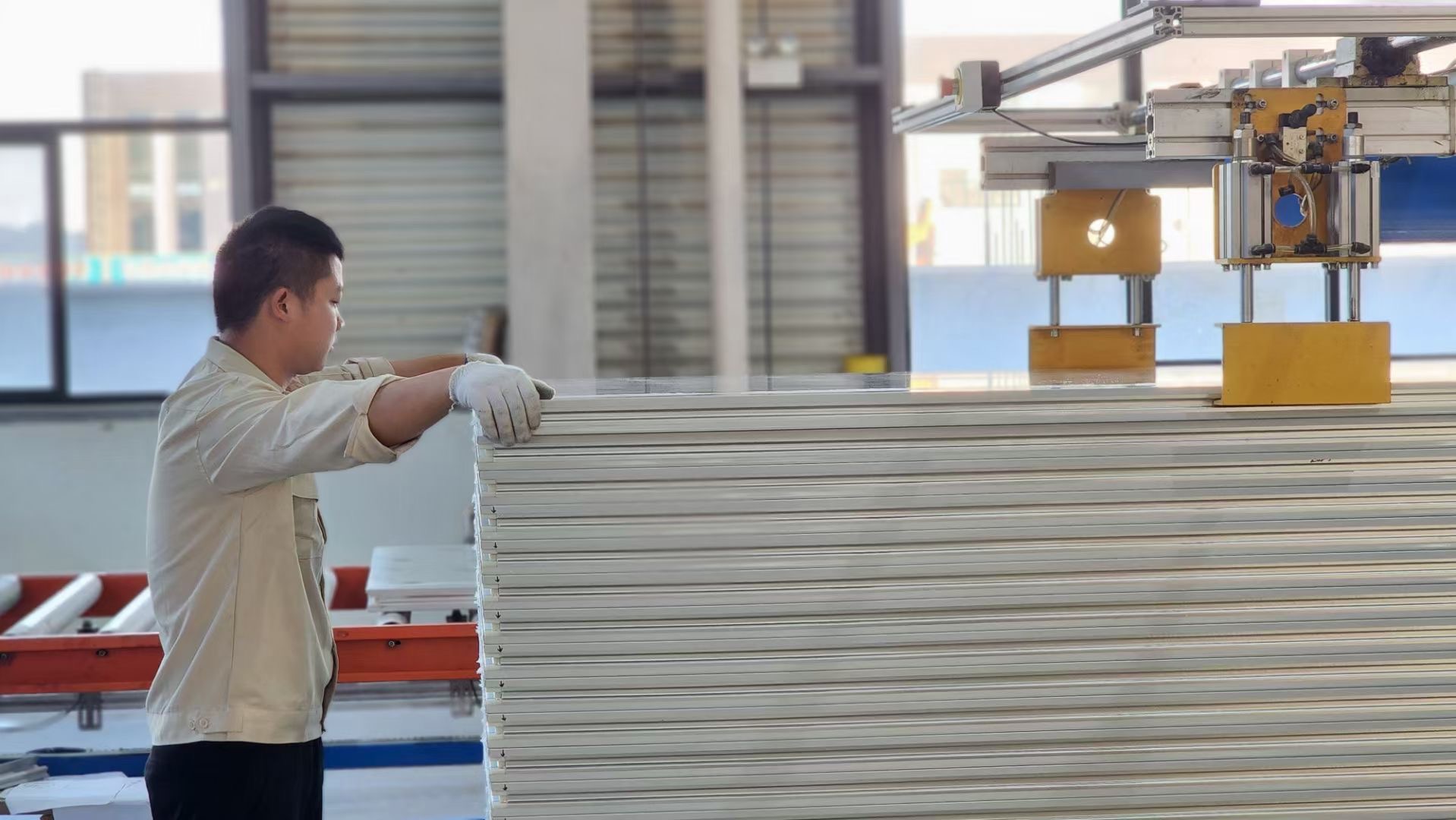 Worker aligning stacked cleanroom panels at AILV