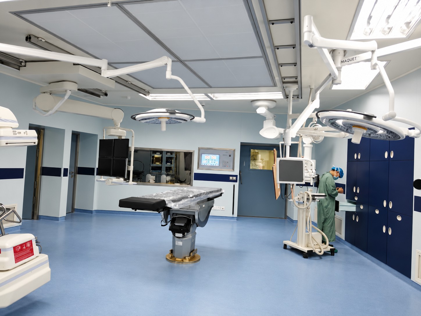 Operating theatre with an examination table, ceiling service fittings and cleanable room surfaces