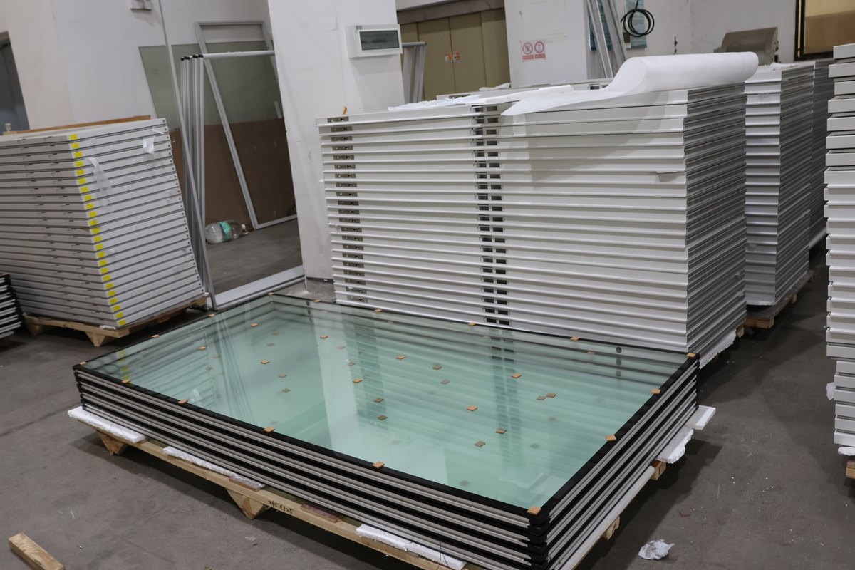 Glazing units stacked on a pallet beside framed components
